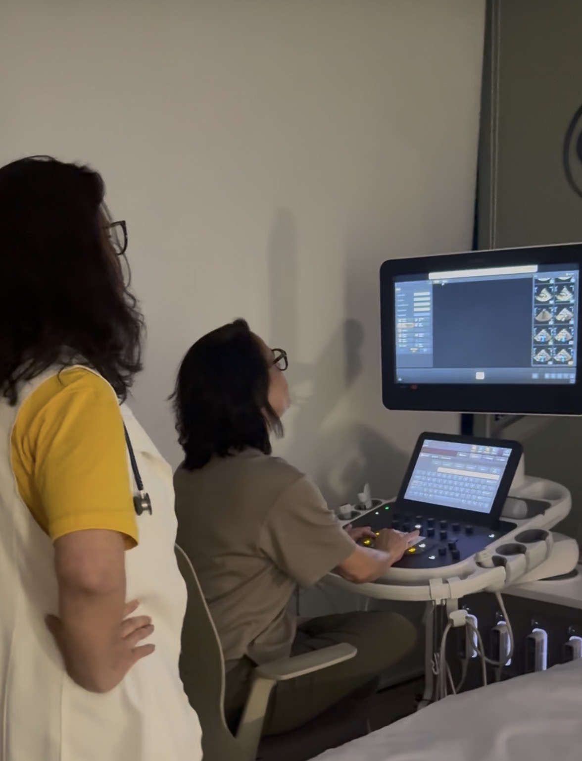 Dra. Lúcia realizando ecocardiograma acompanhada pelo médico assistente